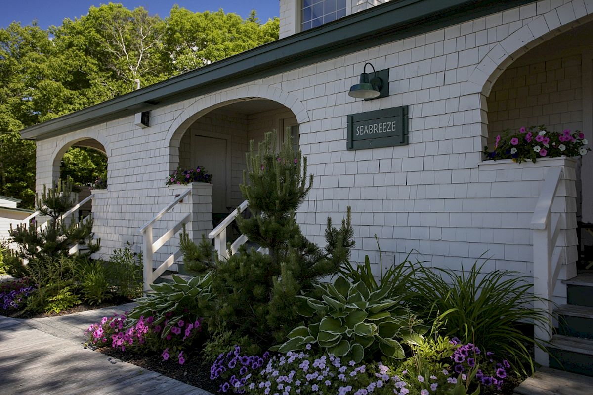 A white house with arched doorways, a green 